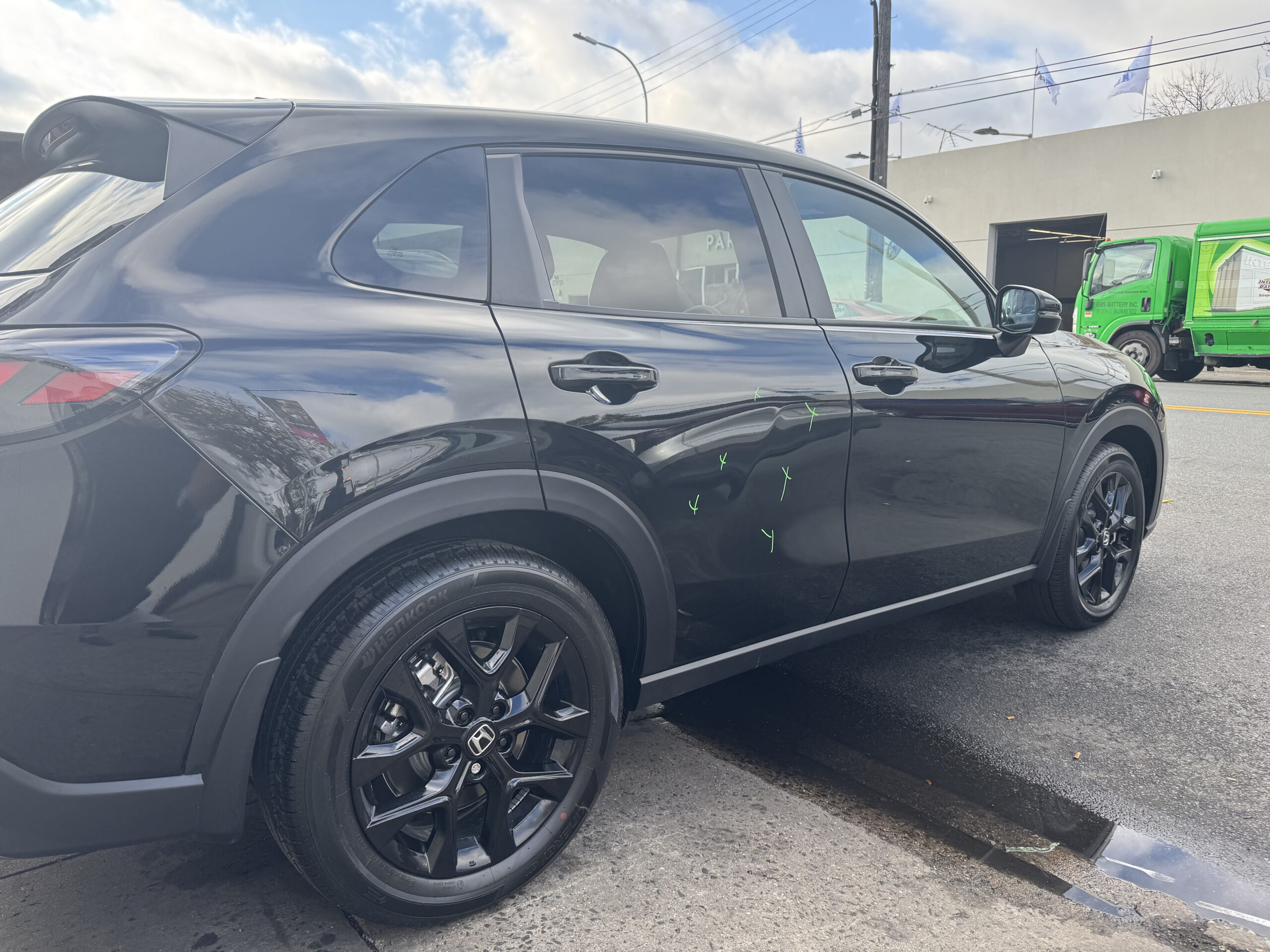 Black SUV with visible dents and collision damage along the passenger-side doors
